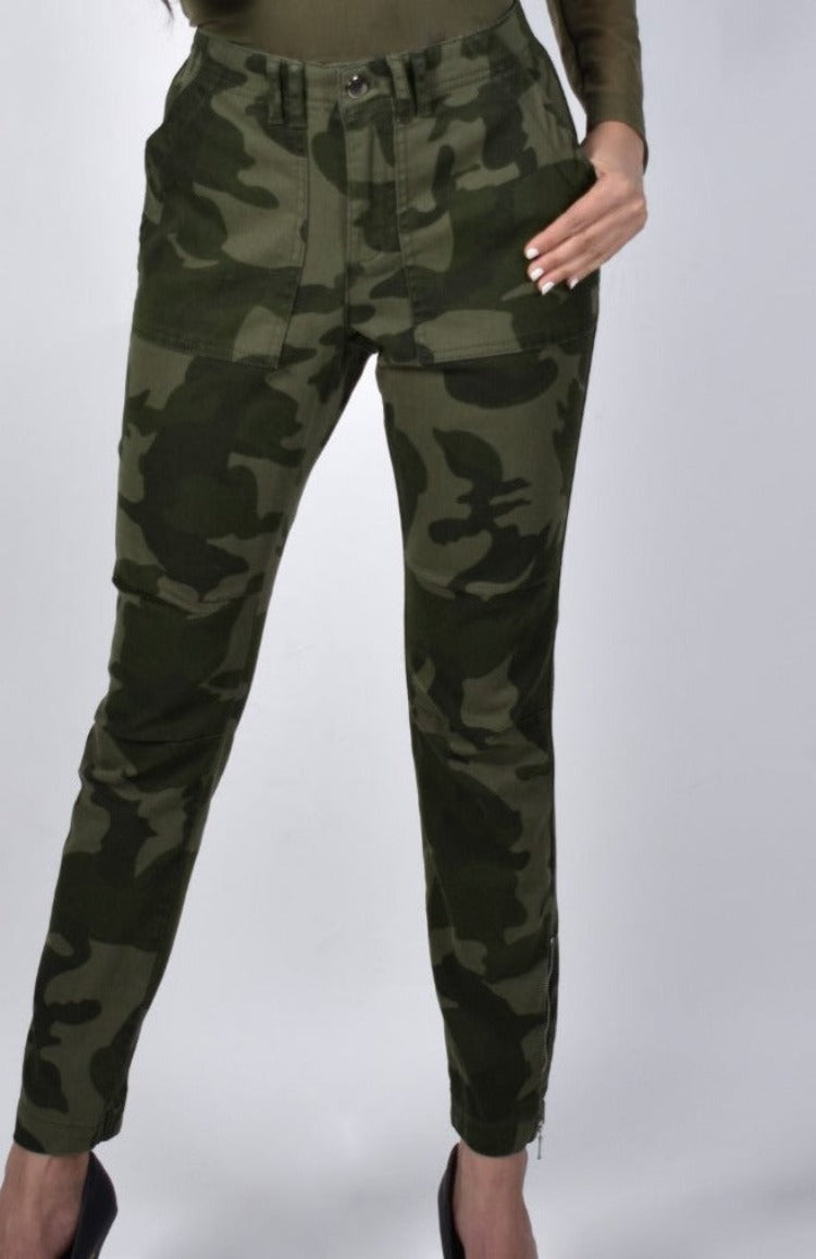 Frank Lyman Camo Pants  Fall in love with these Frank Lyman Camo Pants! These edgy pants feature a button front and zipper closure, square slant pockets, back pockets with button closure, elastic cuff and ankle zippers. So sharp with a black sweater and boots! Proudly designed in Canada.