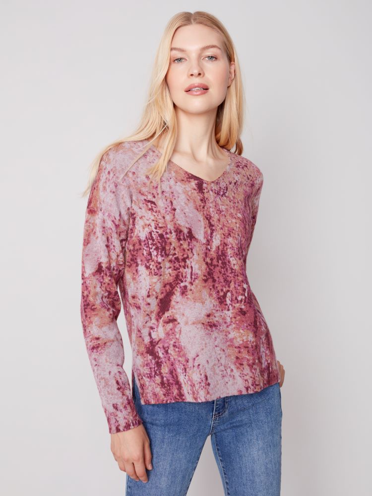 This Charlie B sweater provides a fashionable alternative to traditional knits and offers comfort and style, featuring an elongated V-neck, drop-shoulder styling, and a relaxed fit. An attention-grabbing print makes it perfect for pairing with jeans or trousers for a polished look.