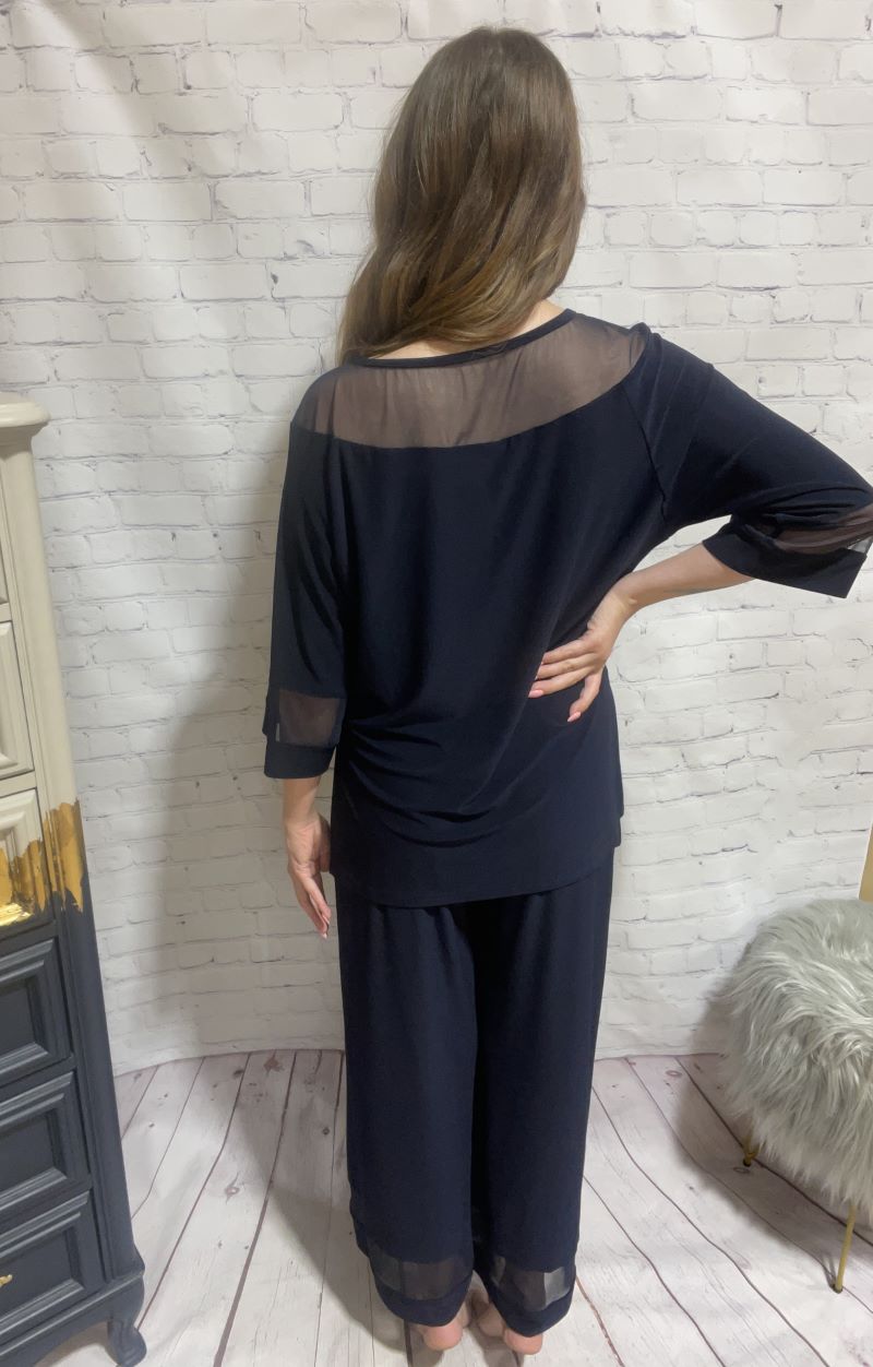 Step out with confidence in this ultra-chic Mesh Panel Wide Leg Jumpsuit from Joseph Ribkoff. The unique look has style and comfort with the soft knit fabric, a boat neckline, dolman sleeves, and chic mesh panels along the neckline, sleeves, and ankles. This jumpsuit will add a touch of je ne sais quoi to your look, keeping you effortlessly ready for any event.