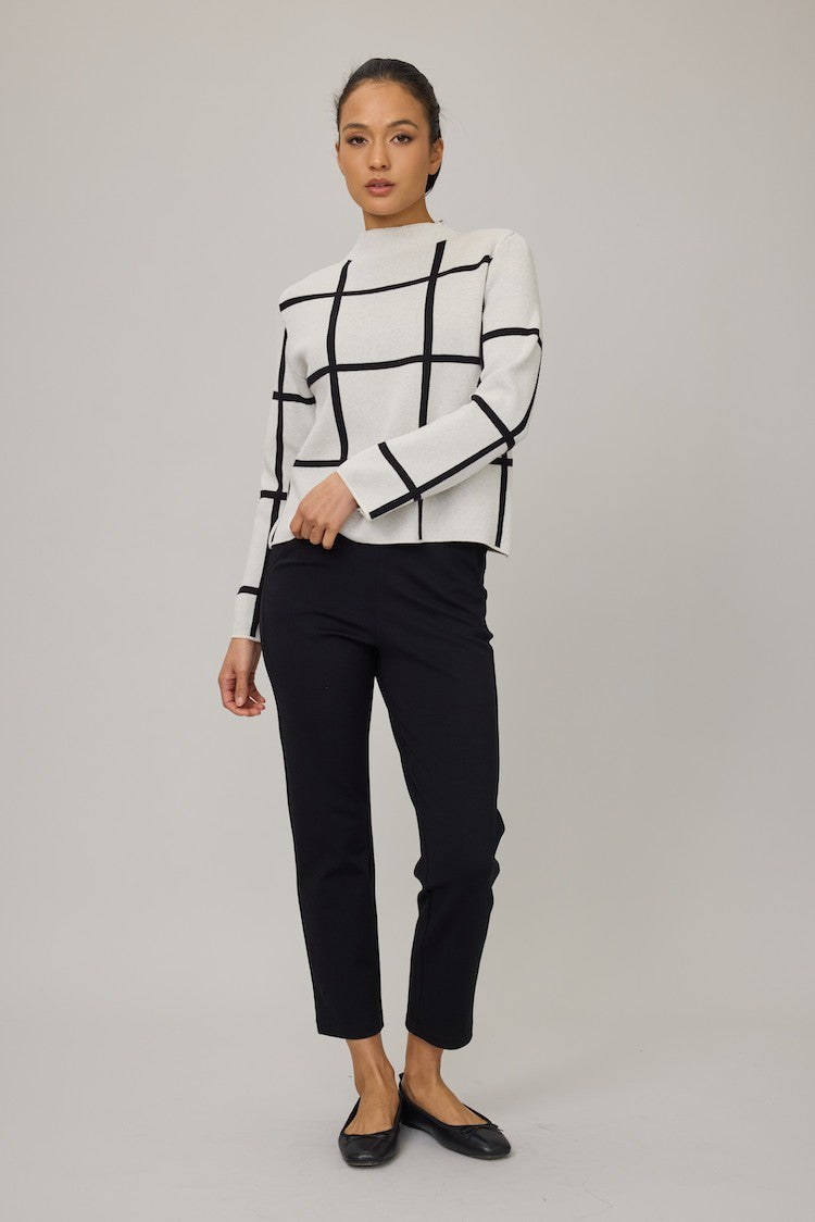 Woman wearing a white and black checkered outfit on a gray background