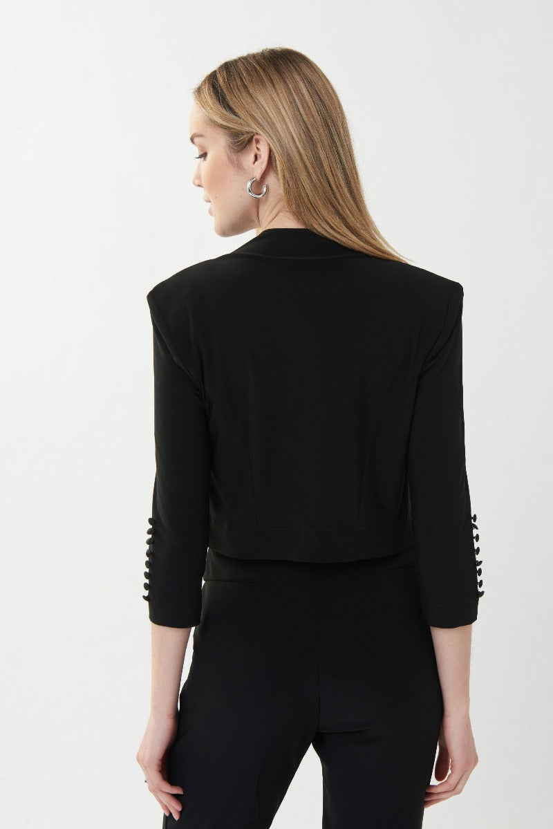 A favorite piece for any wardrobe.  Joseph Ribkoff Bolero Style Top is a lovely cover up.   It features an open front, cropped cut with bold, clean lines, three quarter length sleeves with button detail accents at the elbow.  Beautifully fitted shoulders with shoulder pads for a classically elegant yet modern look.  