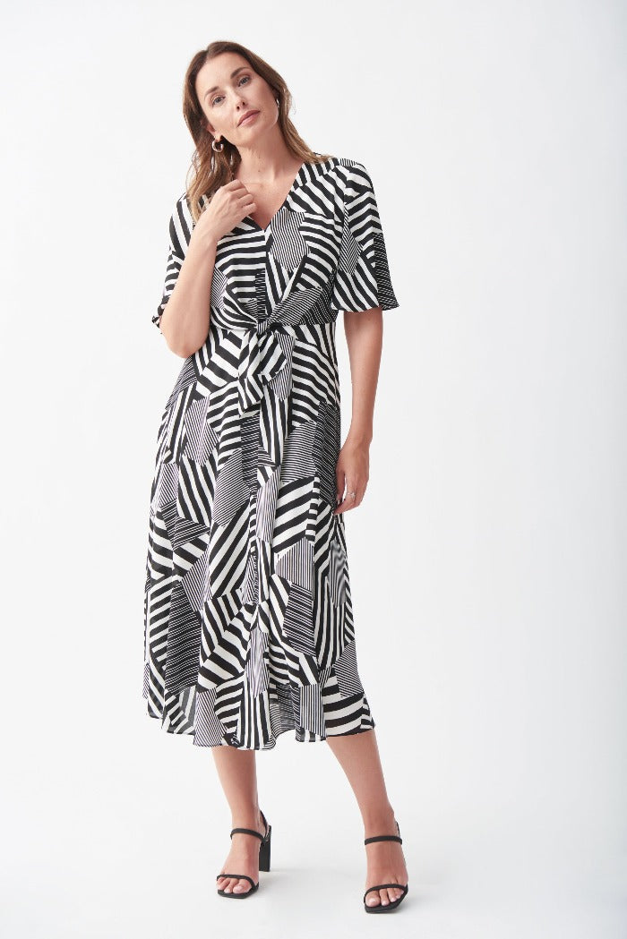 Turn heads in this Patterned Maxi Dress from Joseph Ribkoff! This striking geometric-print dress hits below the knee and features a v-neckline, fluttery elbow-length sleeves, keyhole back, and waist tie. Lined. 
