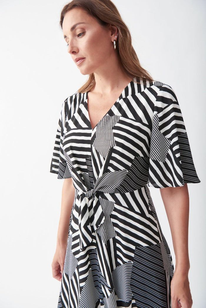 Turn heads in this Patterned Maxi Dress from Joseph Ribkoff! This striking geometric-print dress hits below the knee and features a v-neckline, fluttery elbow-length sleeves, keyhole back, and waist tie. Lined. 