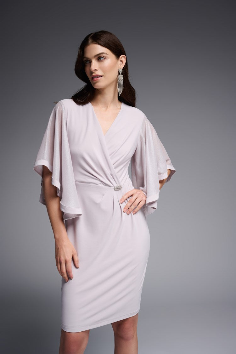Designed for the sophisticated woman, this Joseph Ribkoff Foiled Chiffon Wrap Dress features elegantly ruffled three-quarter length sleeves and a beautiful waist ornament. It is crafted from a sumptuous silky knit fabric that drapes your curves and falls at the knee, ensuring you'll look absolutely stunning wherever you wear it.