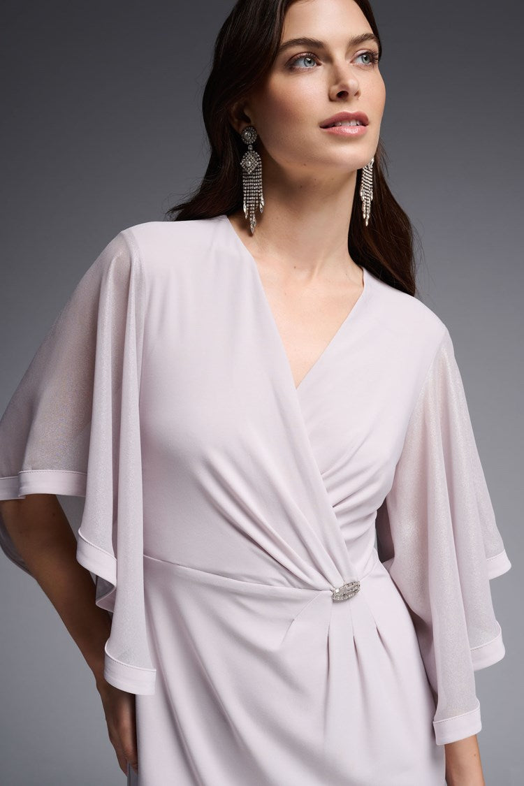 Designed for the sophisticated woman, this Joseph Ribkoff Foiled Chiffon Wrap Dress features elegantly ruffled three-quarter length sleeves and a beautiful waist ornament. It is crafted from a sumptuous silky knit fabric that drapes your curves and falls at the knee, ensuring you'll look absolutely stunning wherever you wear it.