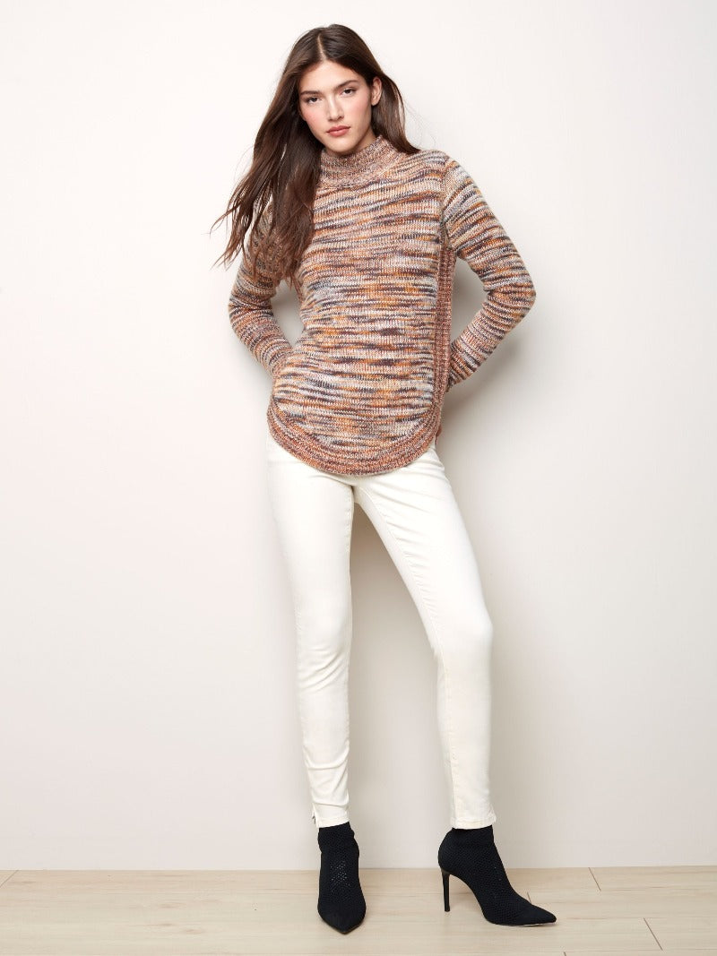 The multi earthy tones in this Charlie B knit Funnel Neck Sweater give you a great look for the season.  The simple funnel neck has long sleeves, a rounded hem and the matching hem pattern along the sides for a fun detail.  Style with a pair of skinny jeans and a high boot for a classy yet casual look.