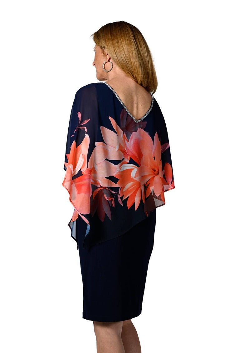 Frank Lyman Floral Overlay Dress  Style: 238348  This luxurious dress features a beautiful harmony of navy silky jersey and coral floral overlay trimmed with glimmering rhinestones. Crafted from 95% polyester and 5% elastane, this elegant piece is sure to make a statement at any event.  For best fit please refer to this size guide,