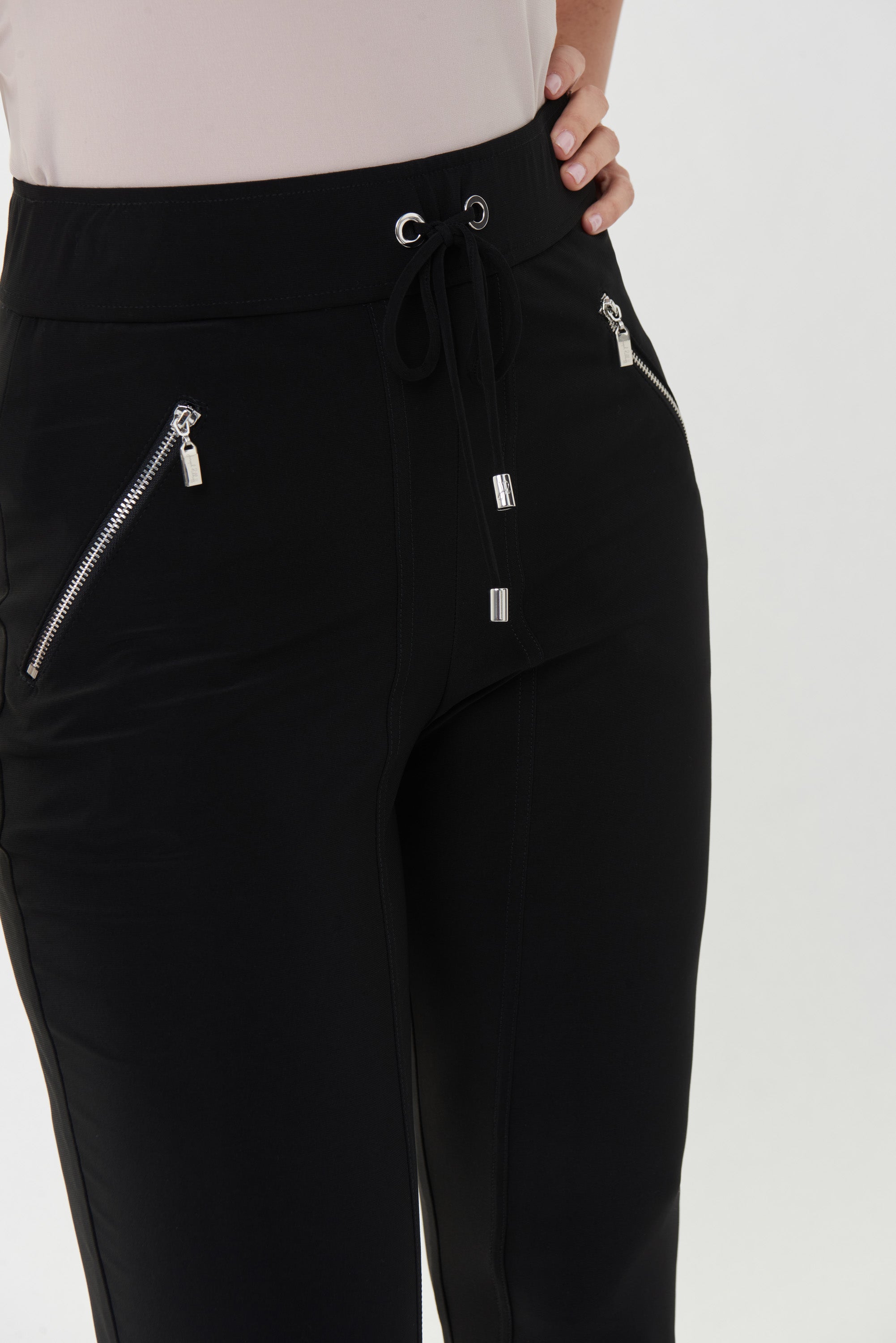 These Joseph Ribkoff Zip Pocket Tie Pants are an easy, comfortable choice for dressing up or down. These have an elastic drawstring waistband, functional angled zip pockets, front seam stitching and are finished with a cuffed jogger style ankle. 