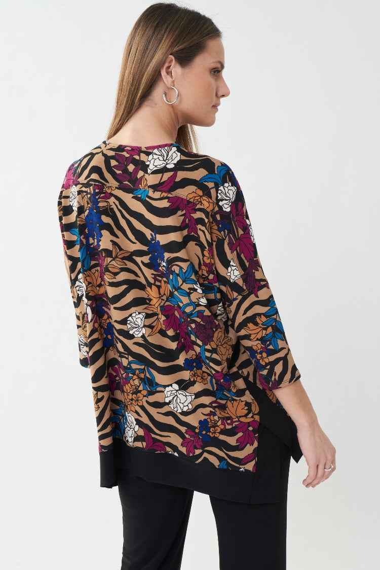 Make a statement in this Joseph Ribkoff Flower Top. Showcasing an attractive flower print with exotic tiger stripes, this top is finished with a round neckline, 3/4 length sleeves and a split, high-low hemline.